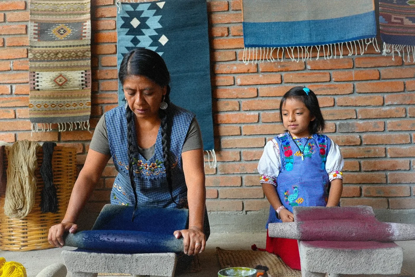 Margarita Guti&eacute;rrez Mart&iacute;nez grinding natural dye on a stone metate in Teotitl&aacute;n del Valle