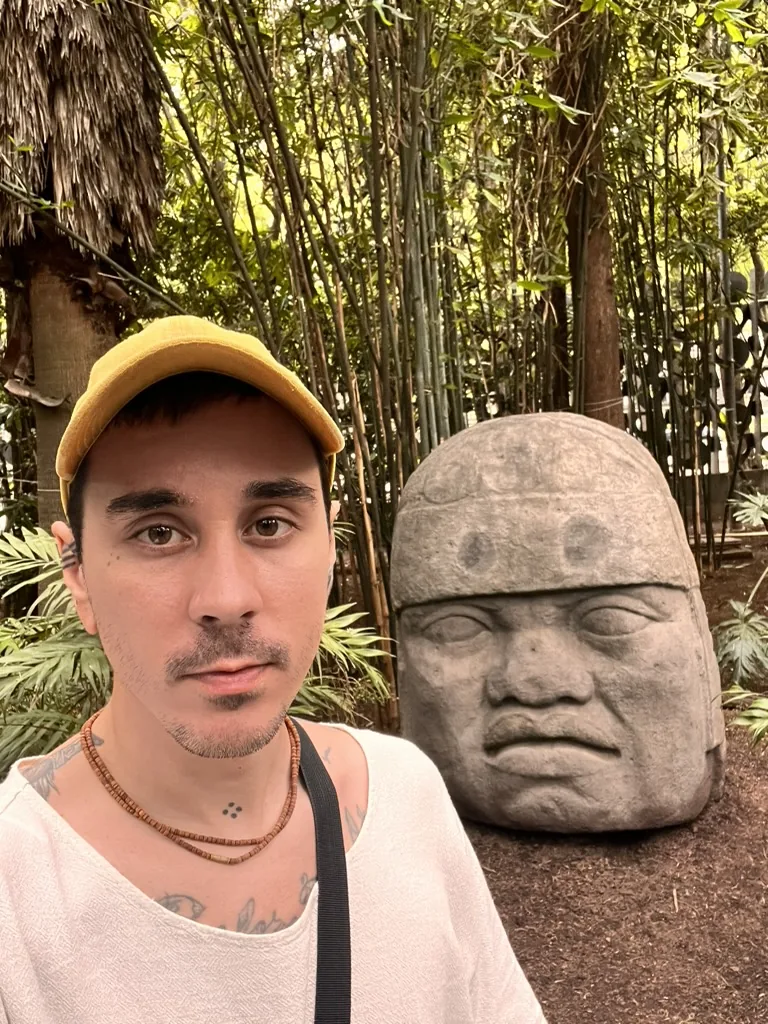 Dakota Wint beside a colossal Olmec stone head
